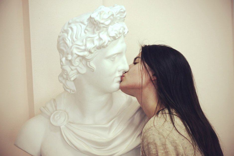 Девушка целует статую
