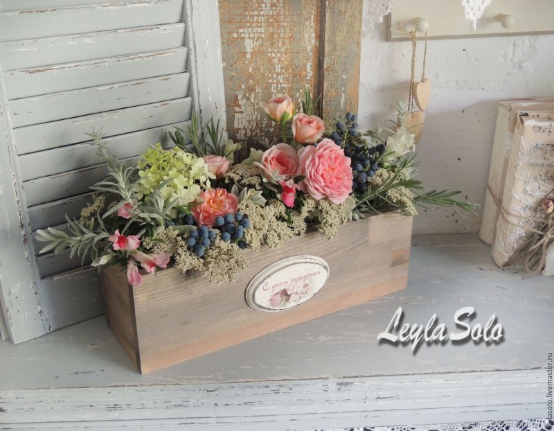 A composition of artificial flowers in the style of Provence in a box