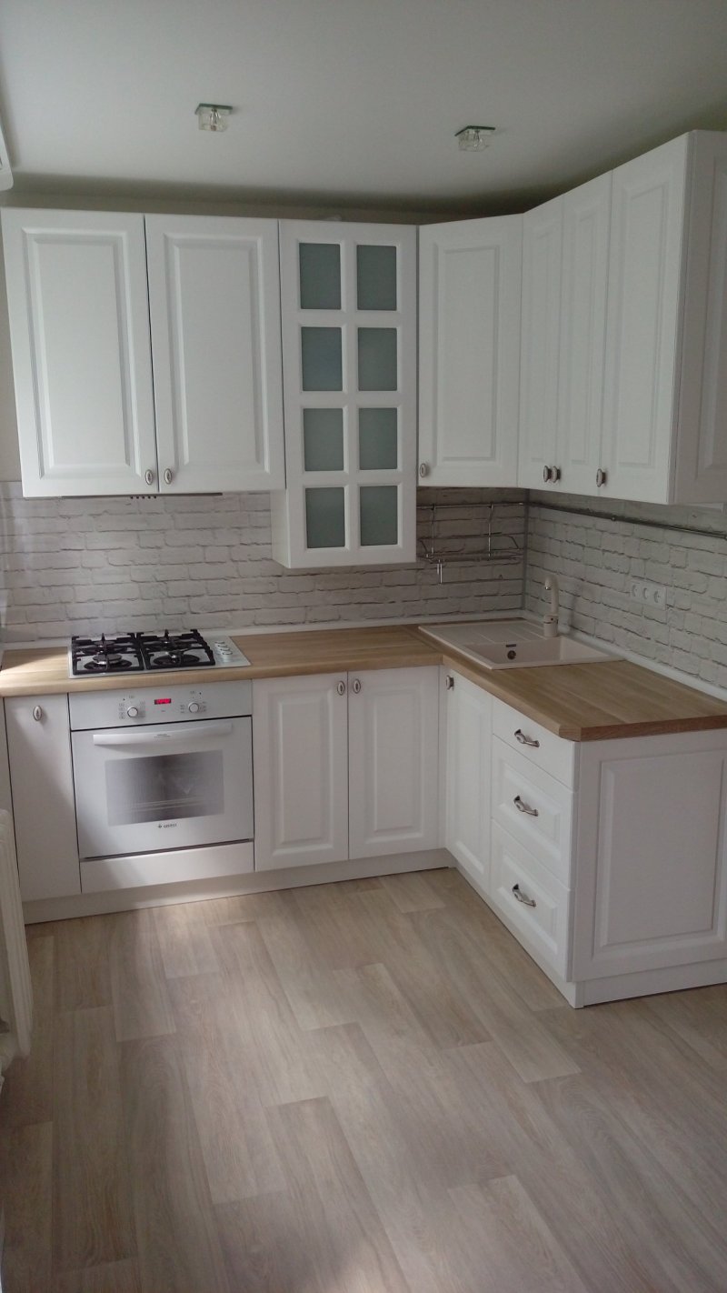 White kitchen with a tabletop under a tree