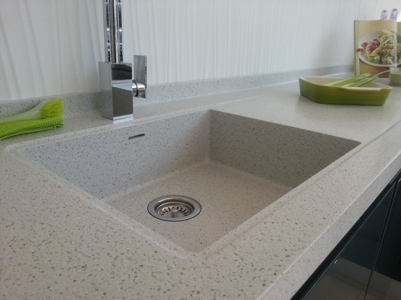 Integrated sink for a kitchen made of artificial stone