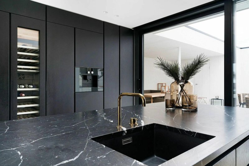 The kitchen is black marble