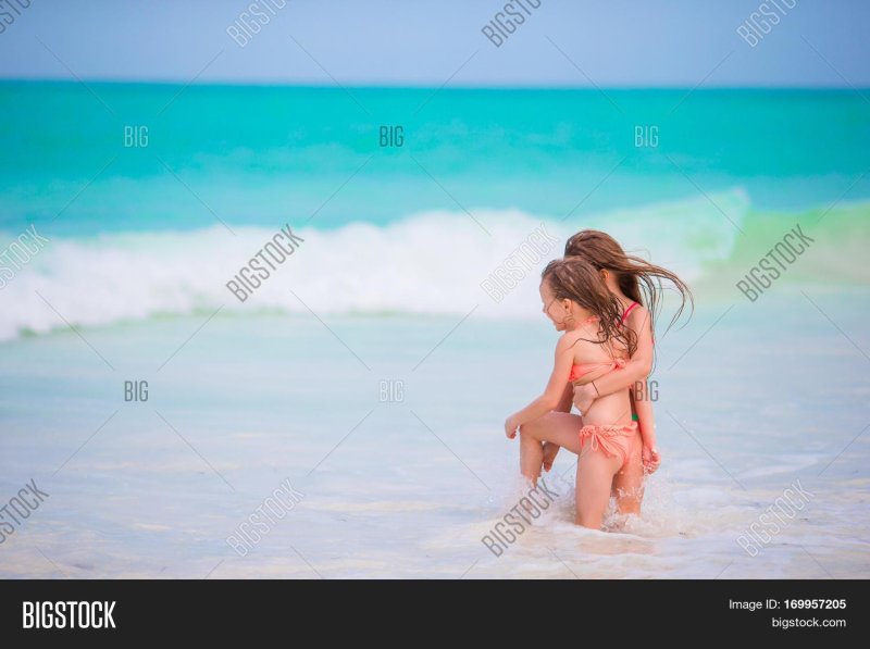 Beautiful mothers and daughters on the beach