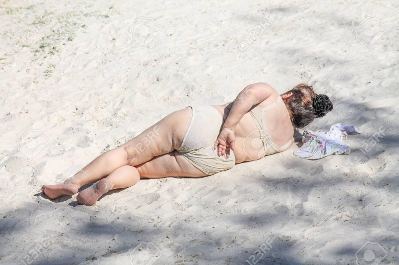 Adult women lie on the beach