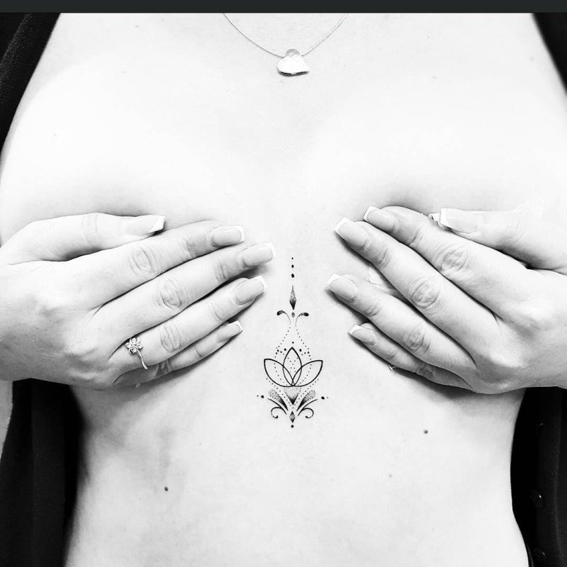 Unalome tattoo between the sternum