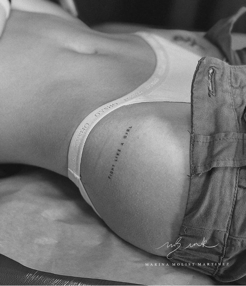 On the thigh is a tattoo