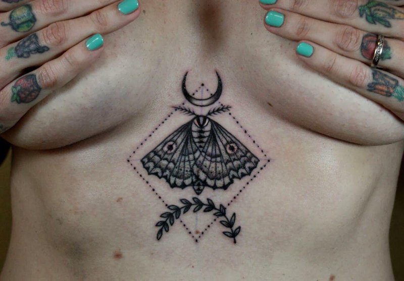 Moth tattoos under the chest